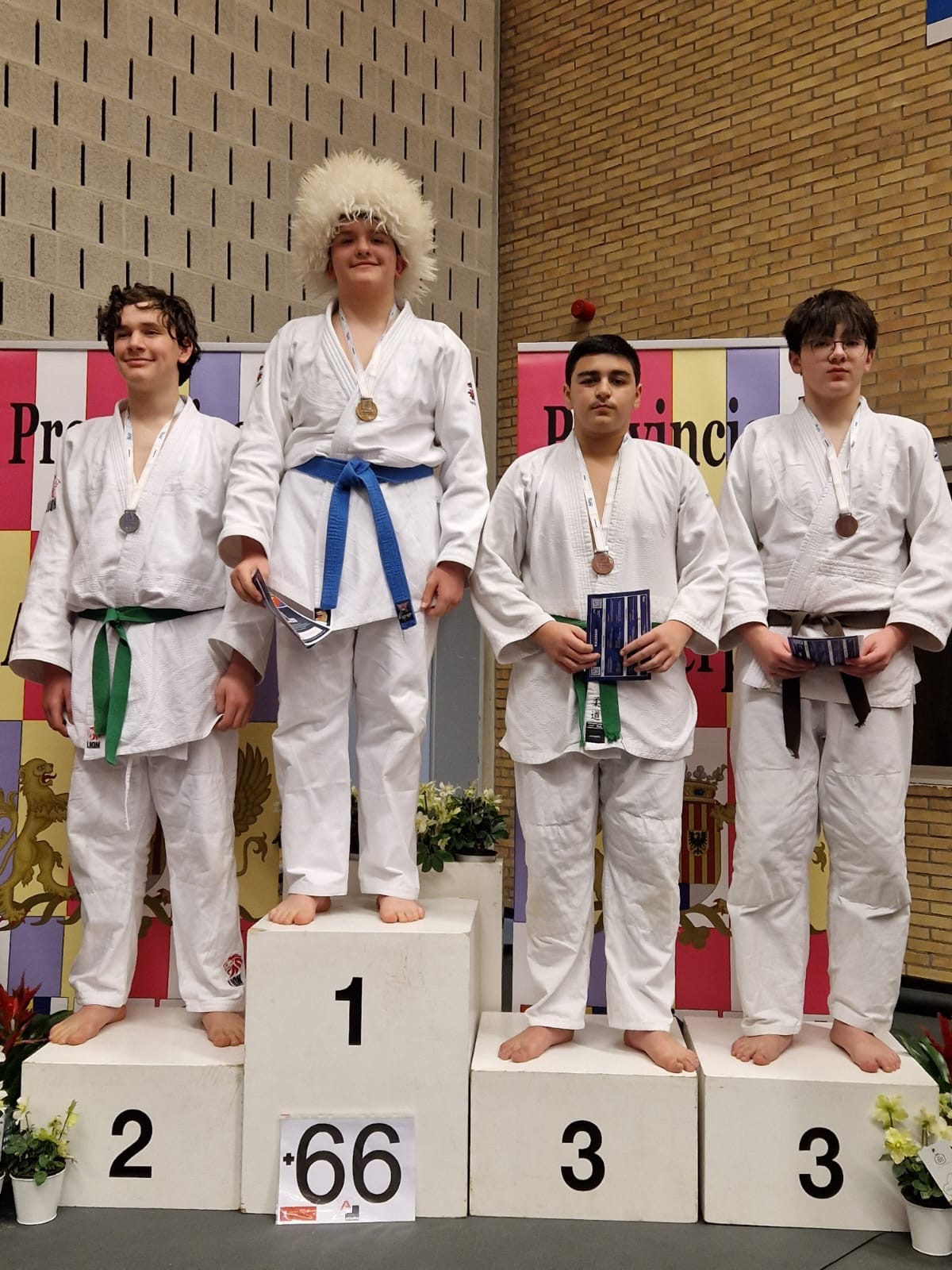 Jongens in judogi staan op podiumplaatsen na een wedstrijd judo